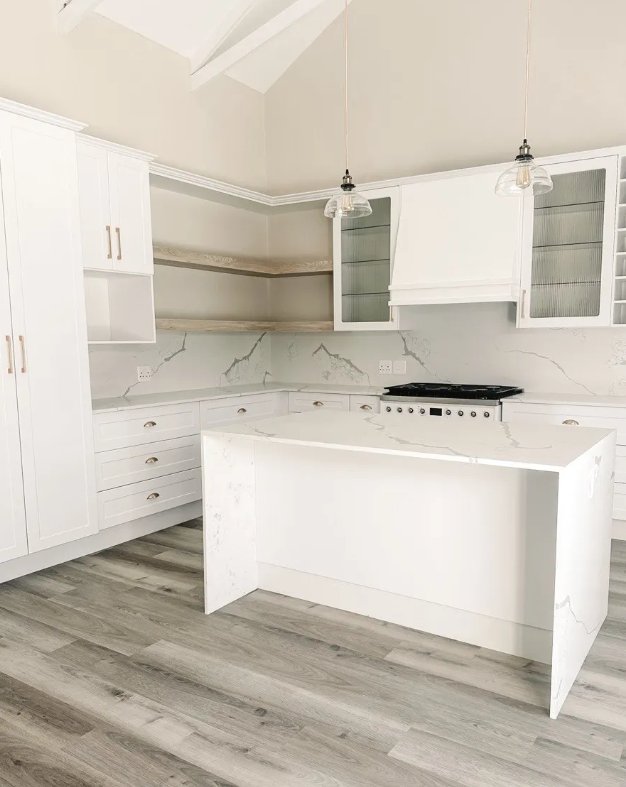 A compact bright kitchen with white cabinetry, open shelves and an island