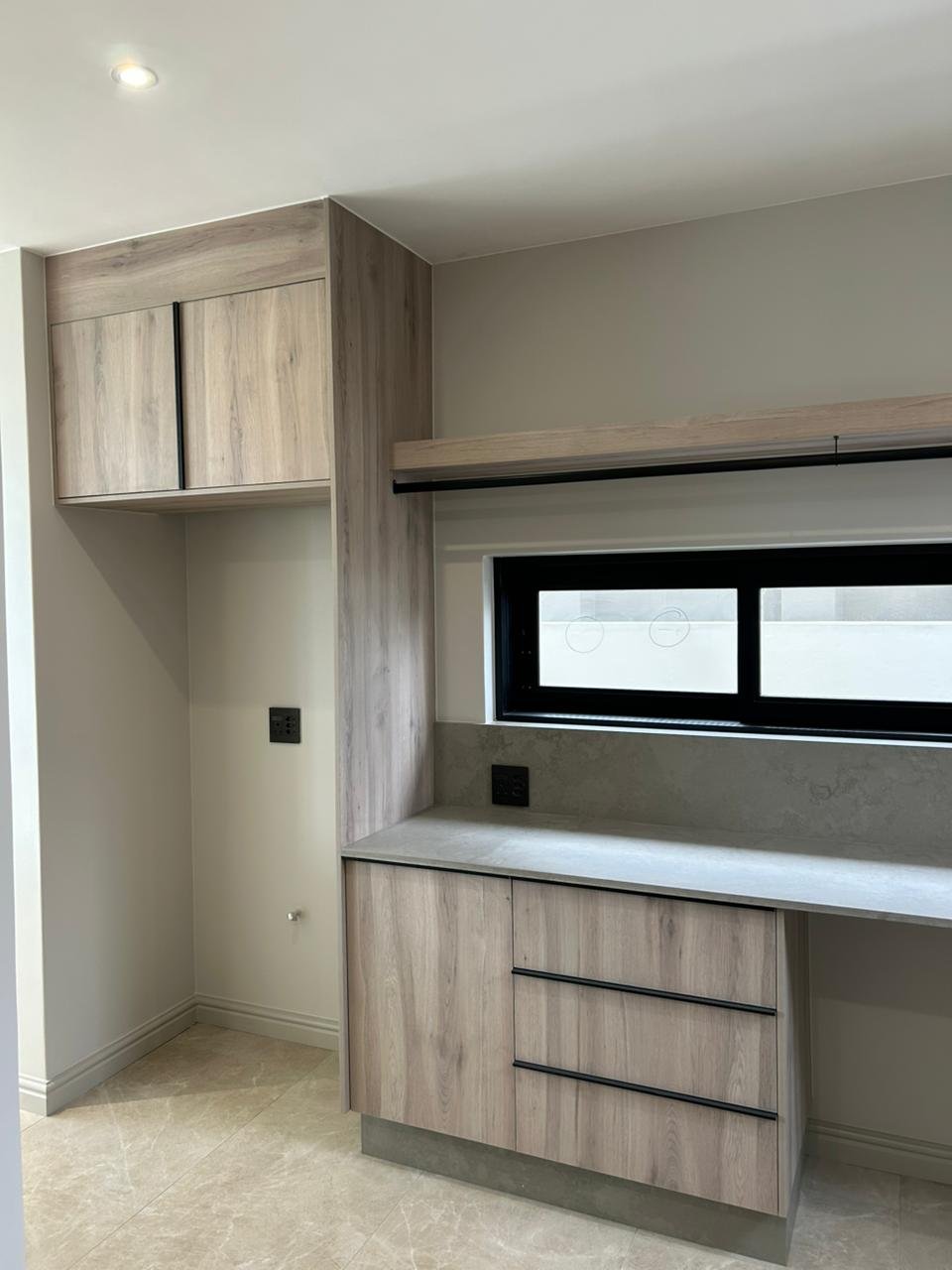 Custom study desk in wood with concealed cabling and floating cupboards